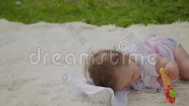 公园里一个很小很漂亮的女孩在床单上玩耍。